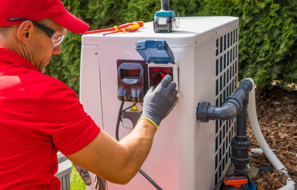 Outdoor Swimming Pool Heat Pump Maintenance Performed by Professional Pools Specialist. Caucasian Male in His 40s.
