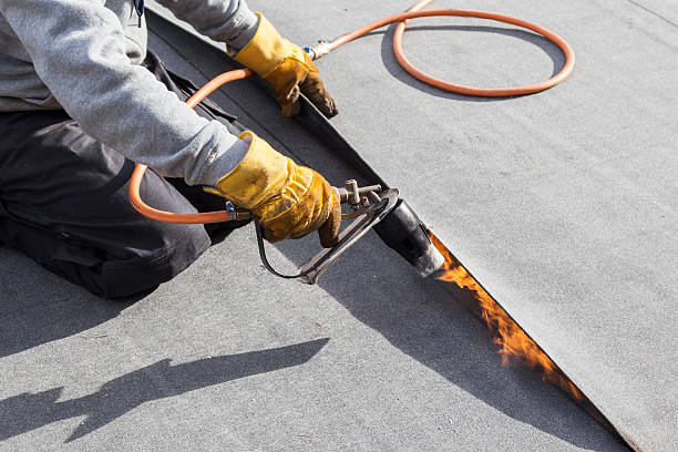 roofer burning asphalt felts on the garage roof - for more click here